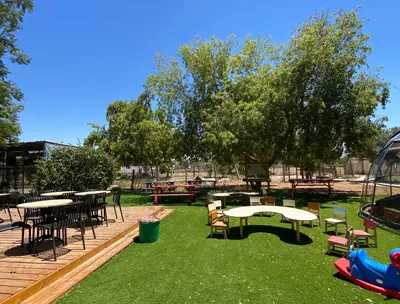 חצר משחקים ודק עם שולחנות קפה